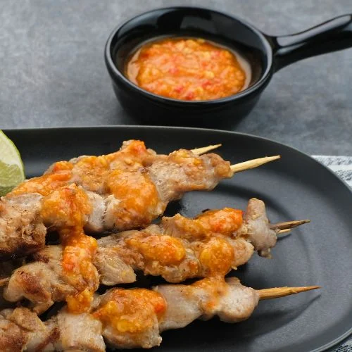 Plato con brochetas de pollo estilo satay con salsa cacahuetes