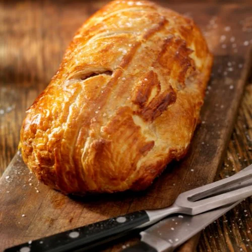 Wellington con la freidora de aire 9 Wellington encima de tabla madera con cuchillo y tenedor