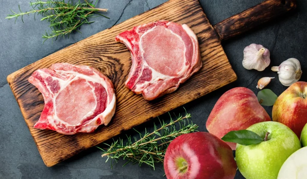 chuletas de cerdo con manzanas en tablas de cortar
